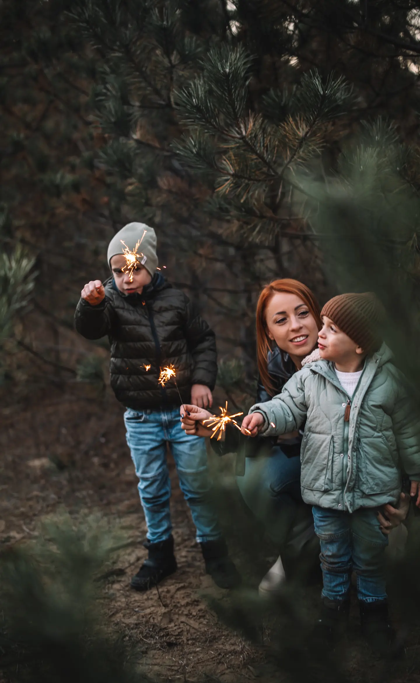 Anyuka két kisfiával csillagszórókat gyújt egy őszi erdei fotózáson