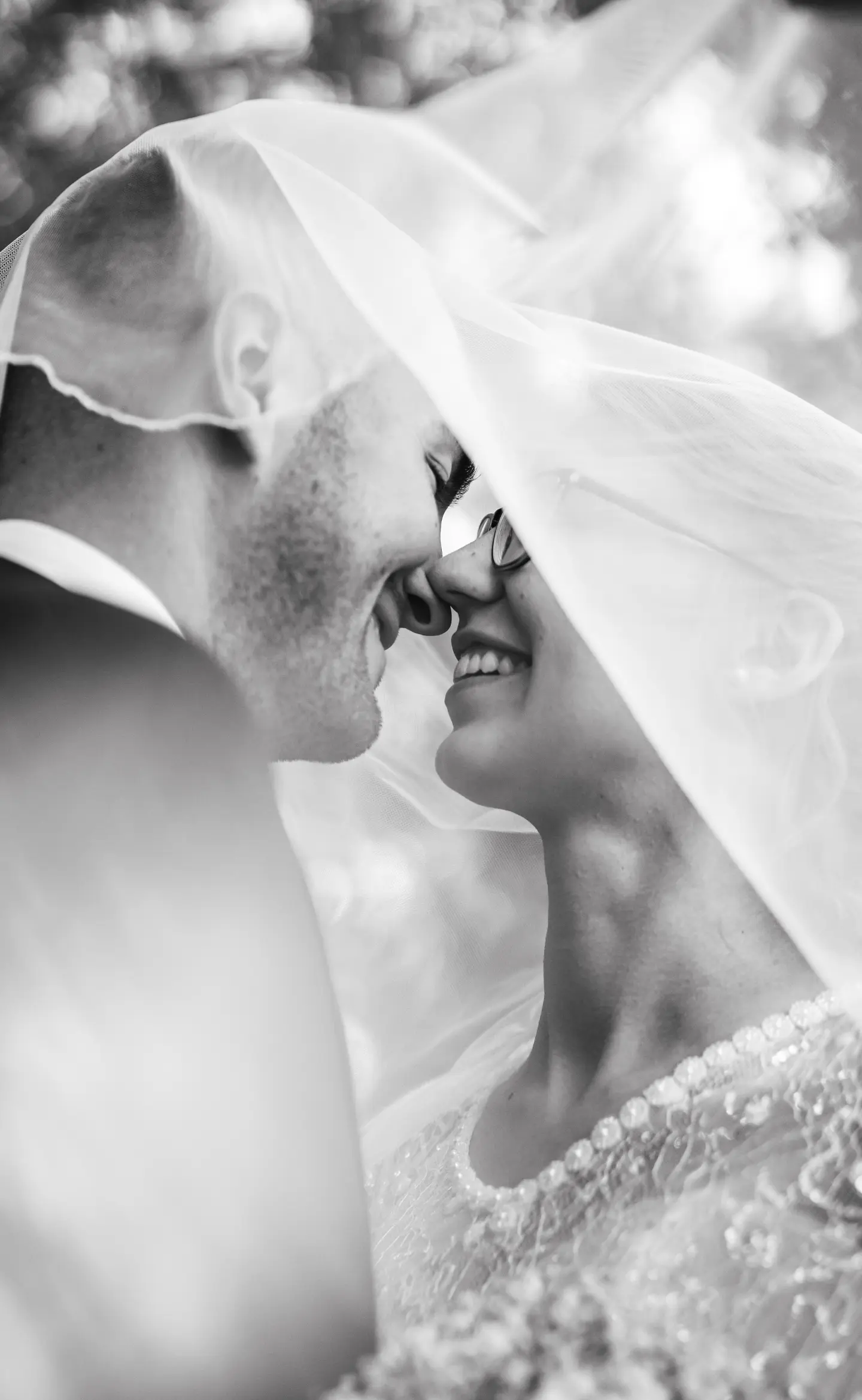 Menyasszony és vőlegény nevetve a fátyol alatt