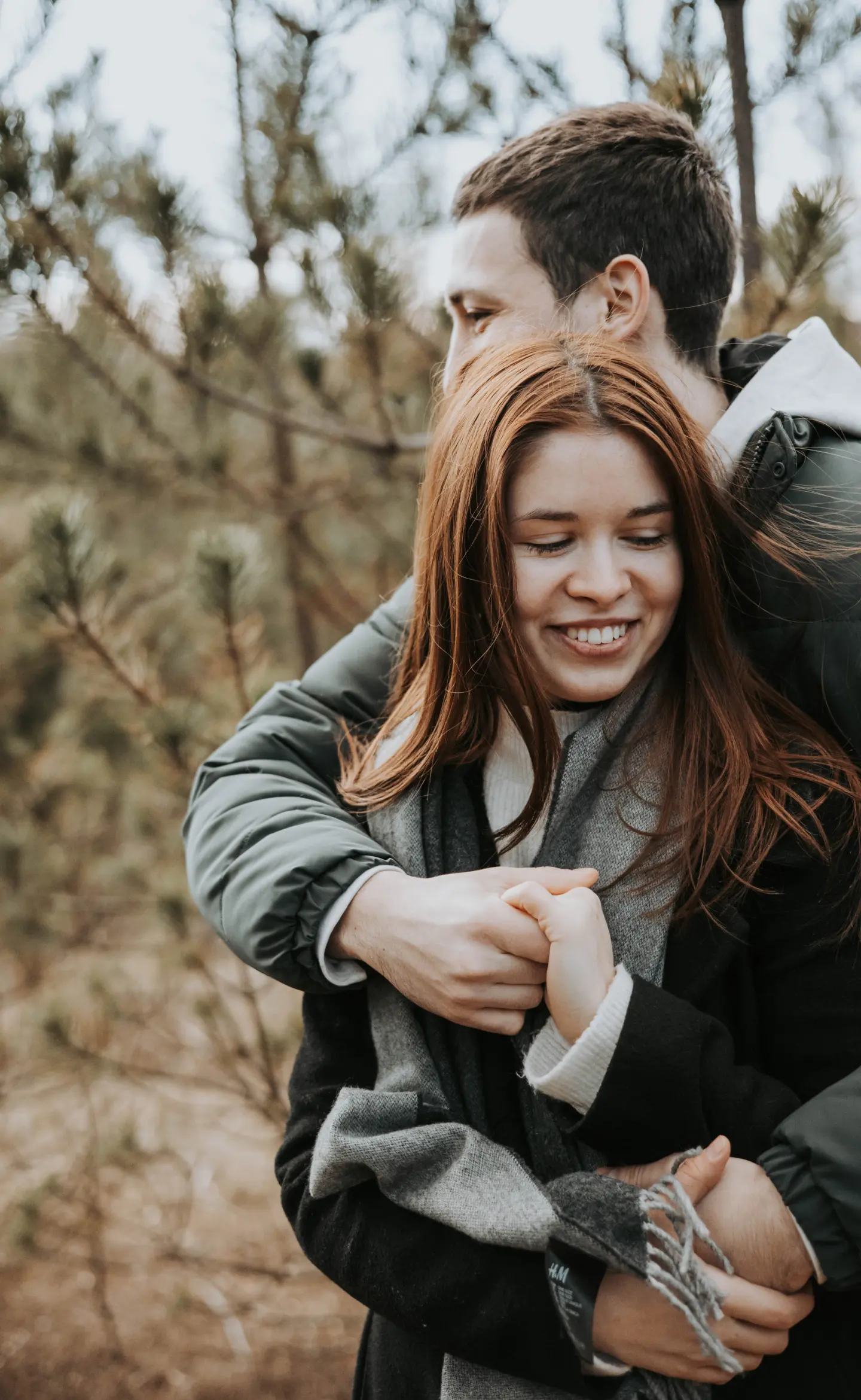 Fiatal pár ölelkezik egy erdei fotózáson
