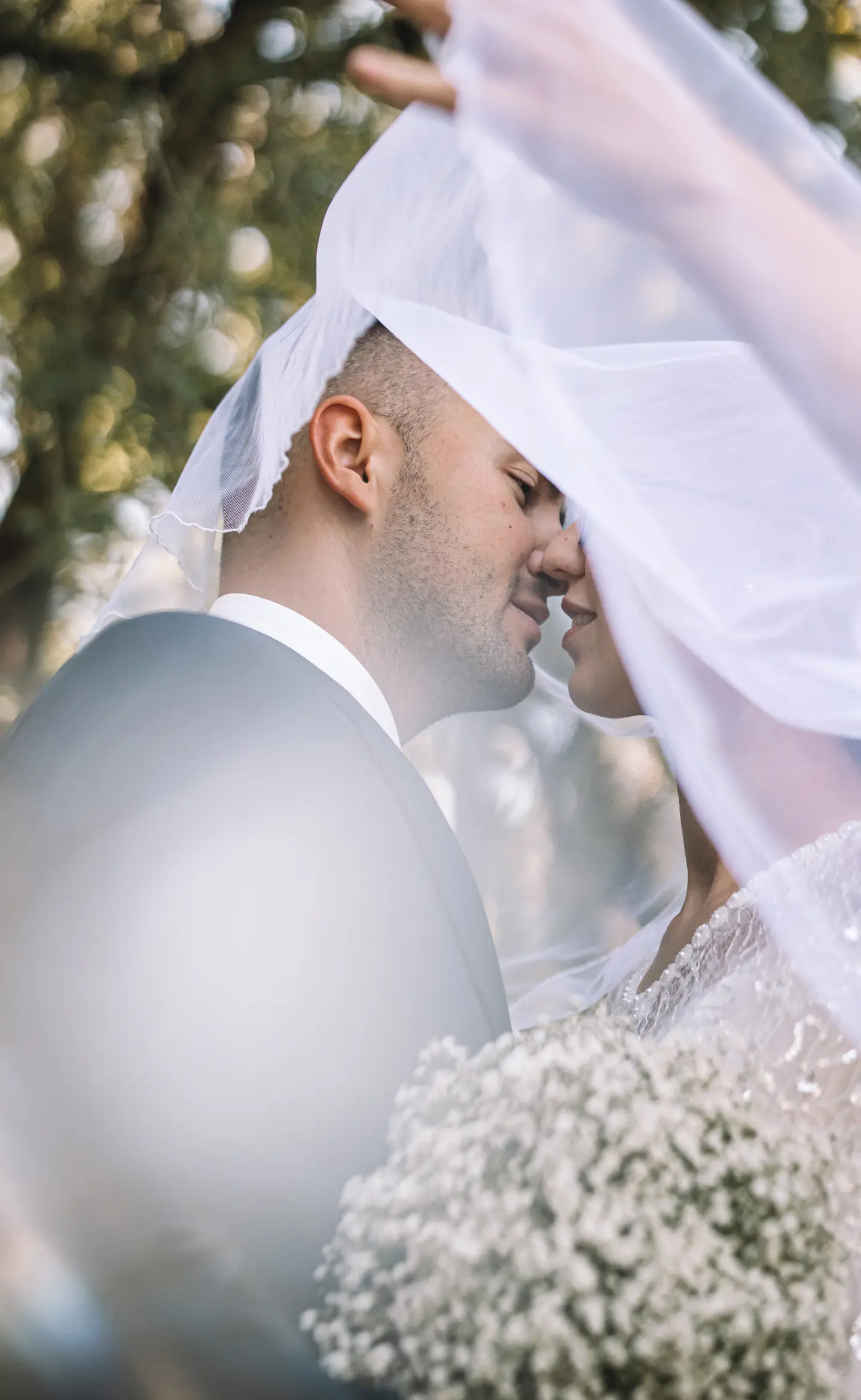 Esküvői pár közelről, fátyol alatt meghitt pillanatban