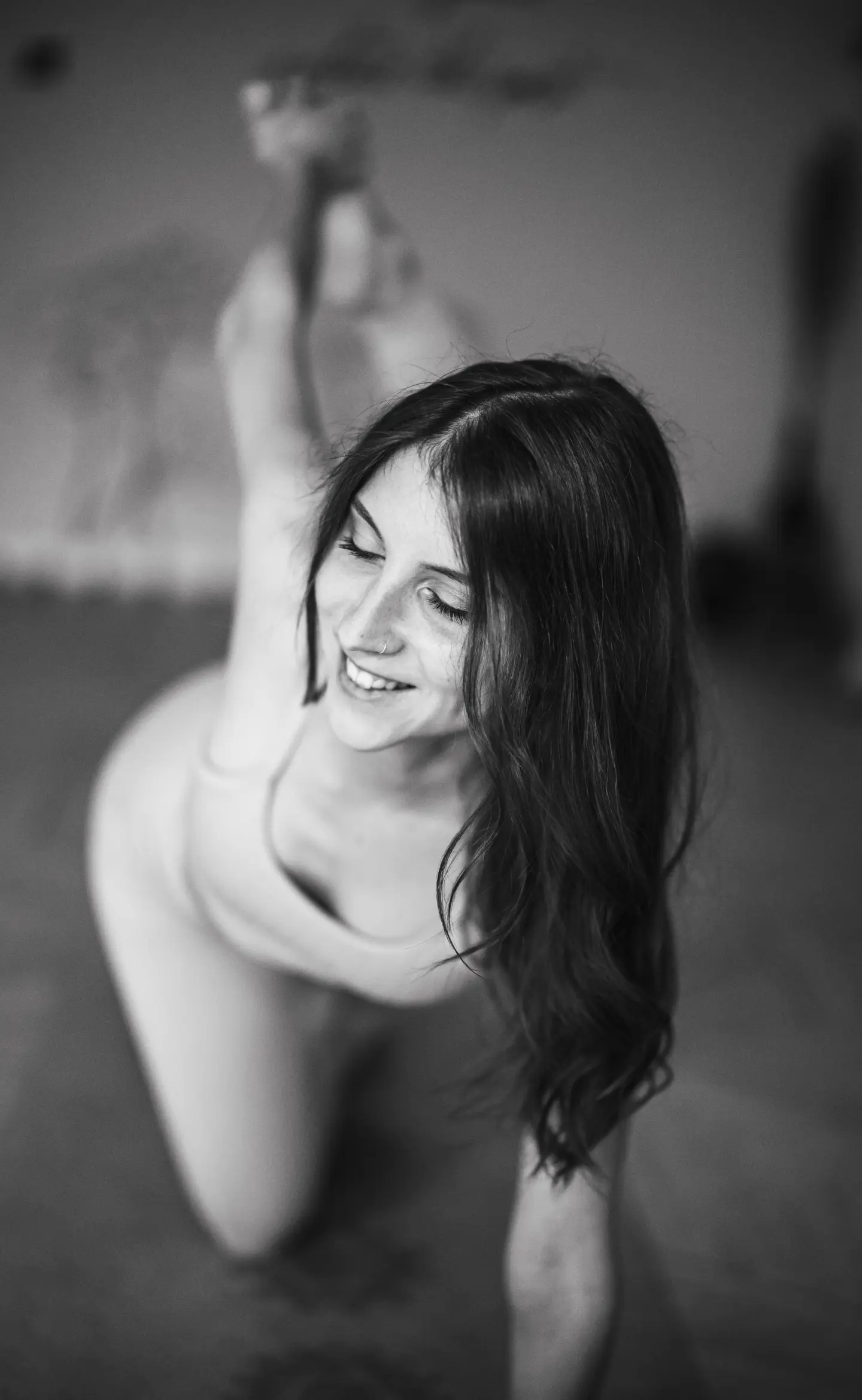 portré fotózás, ahol egy hosszúhajú lány éppen egy jógapózt mutat be, közben mosolyog