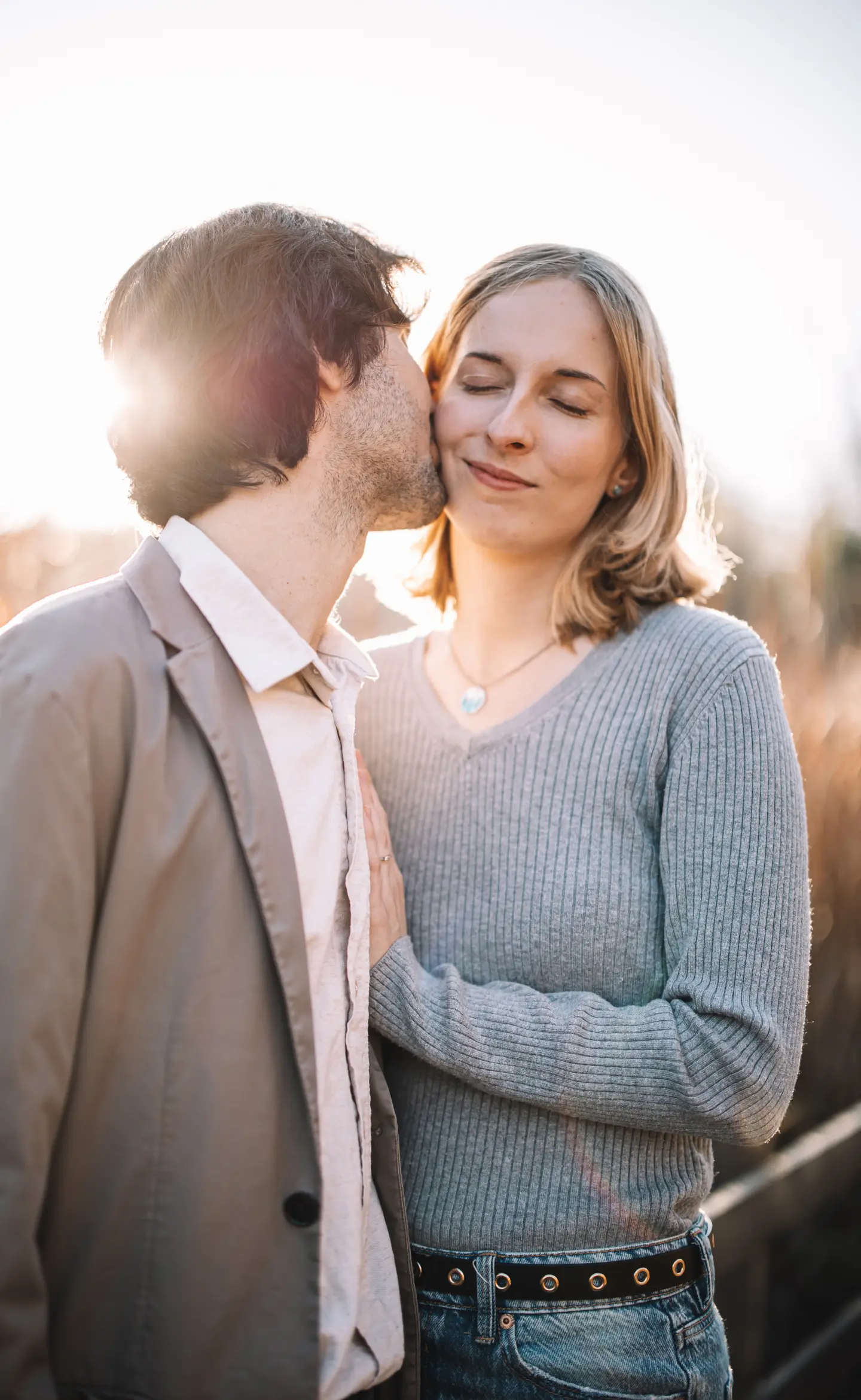 Férfi puszit ad a nő arcára, napfényben, lifestyle jegyes fotózás