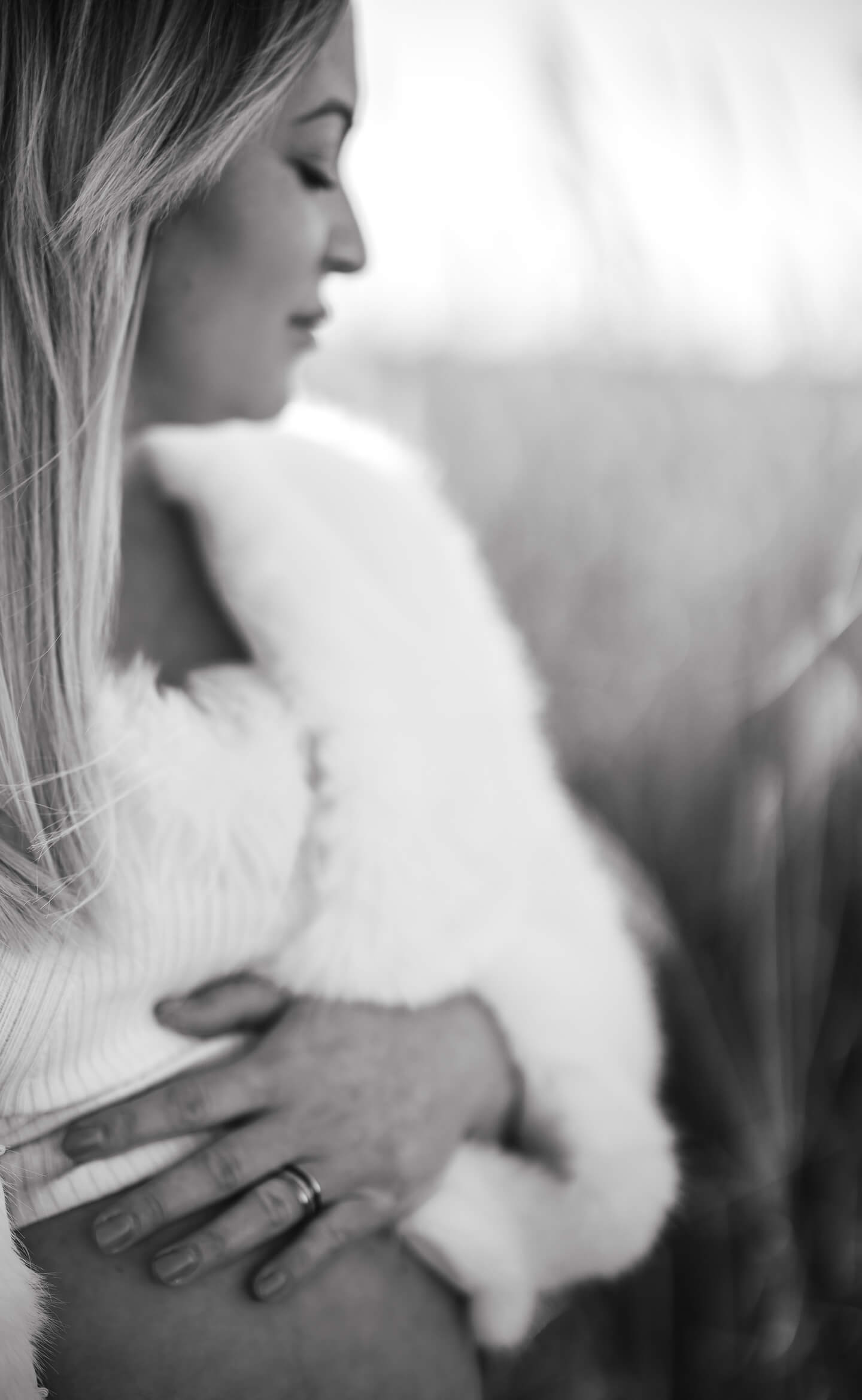 Várandós nő gyengéden a hasára tett kézzel, természetes fényben, lifestyle kismama fotózás