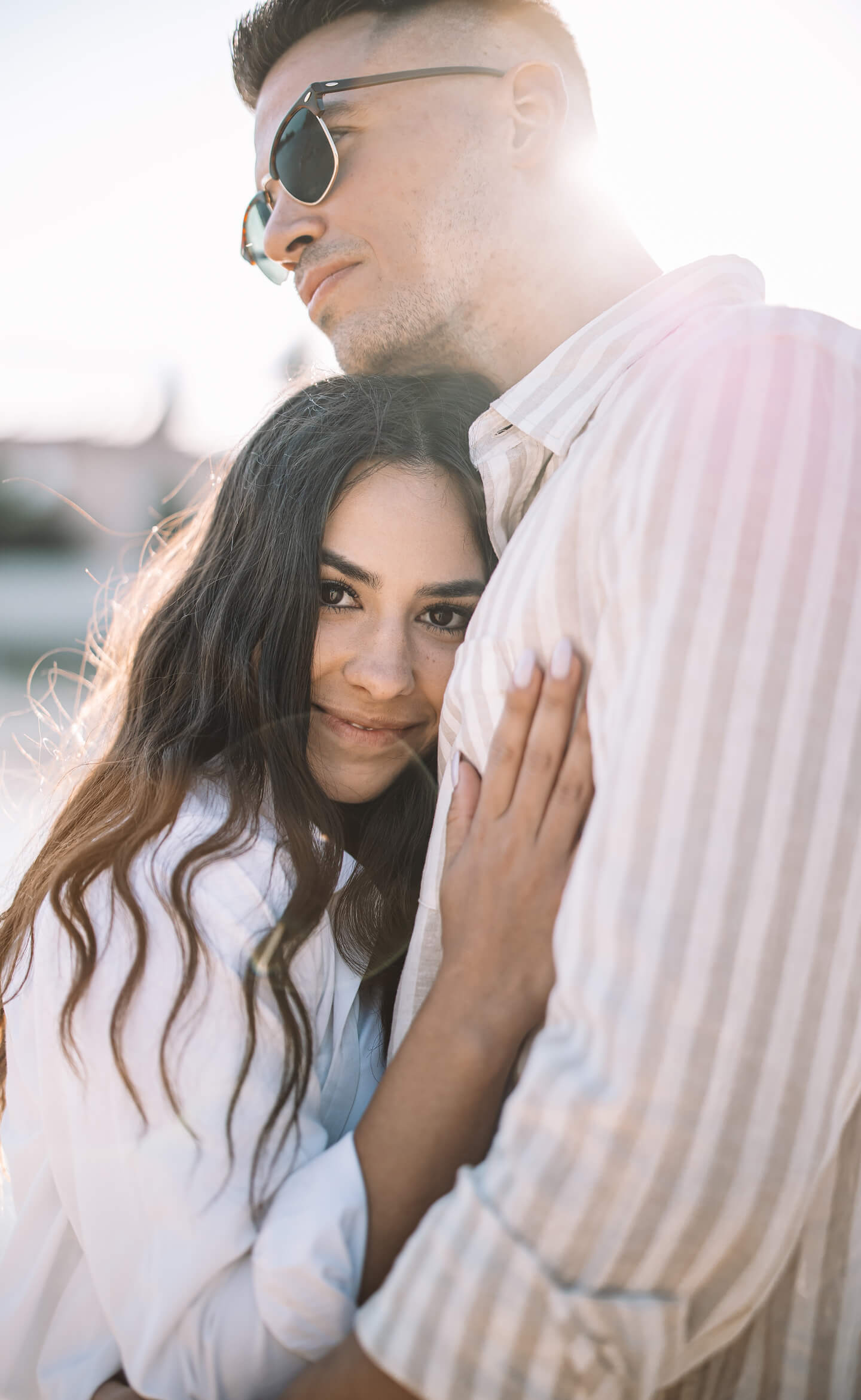 Lány szeretettel bújik a párjához, közeli lifestyle portré napfényben