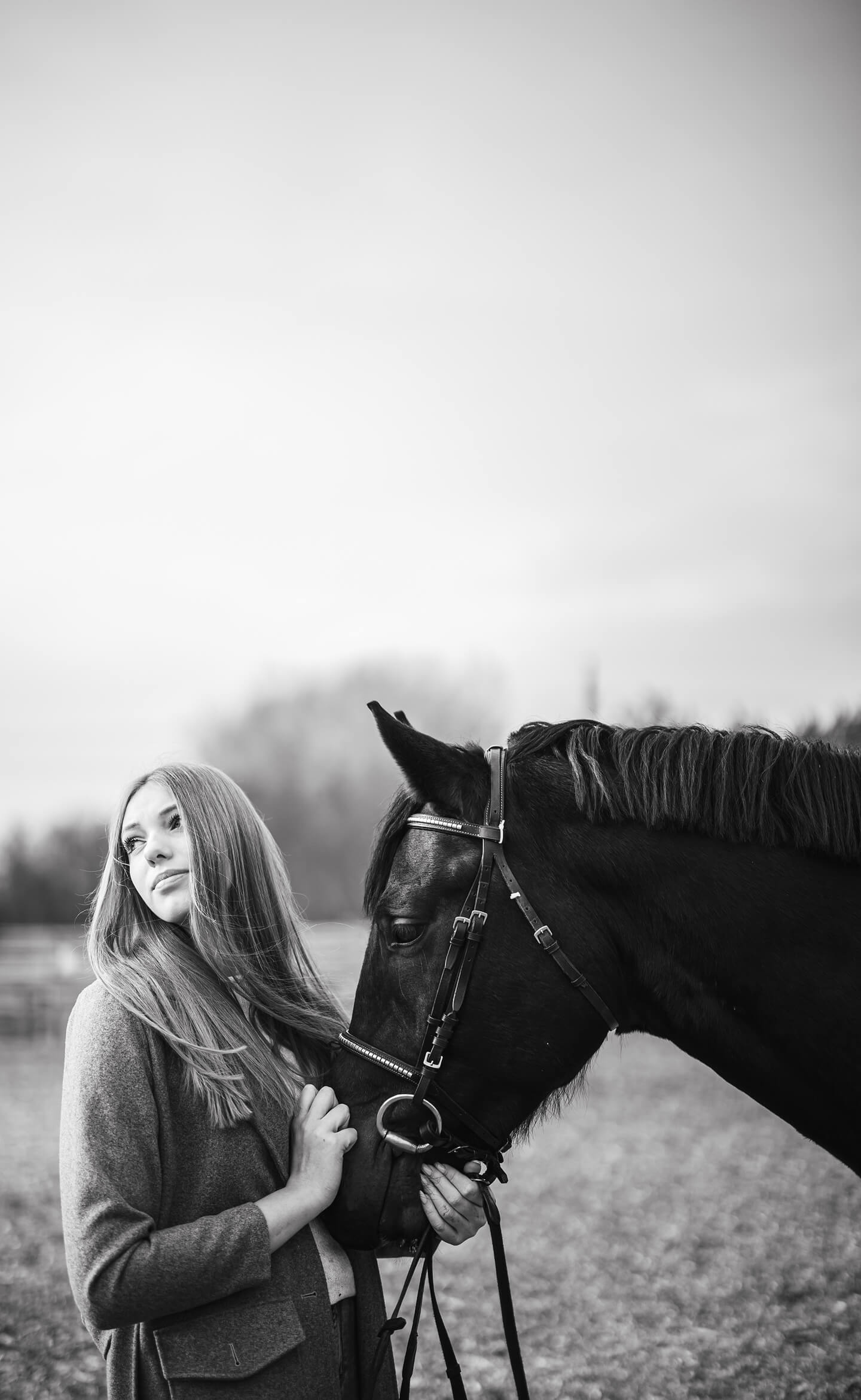 Fiatal nő lóval, meghitt pillanat egy fekete-fehér portréfotón